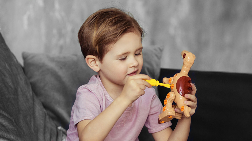 Enfant qui joue avec un jouet dinosaure